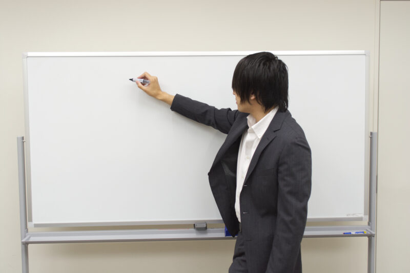 ホワイトボードに書き込むビジネスマン